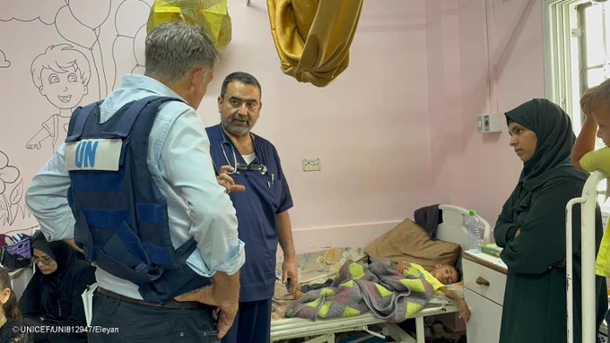 UNICEF Spokersperson talks to a doctor and family of a child who is severely malnourished and lying on a bed