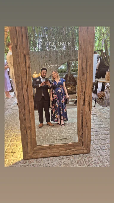 A photo of a couple taking a selfie in a mirror