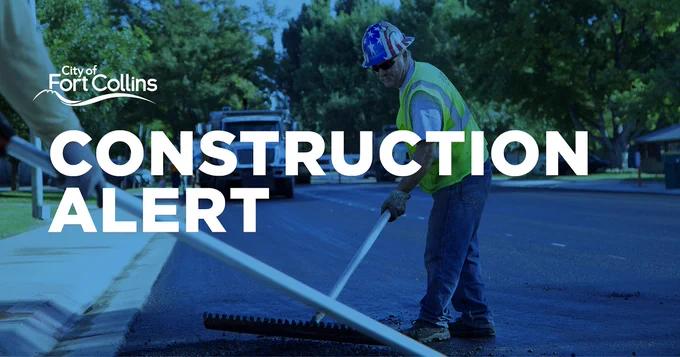 A Streets employee raking material over a newly paved street with text reading "Construction alert"