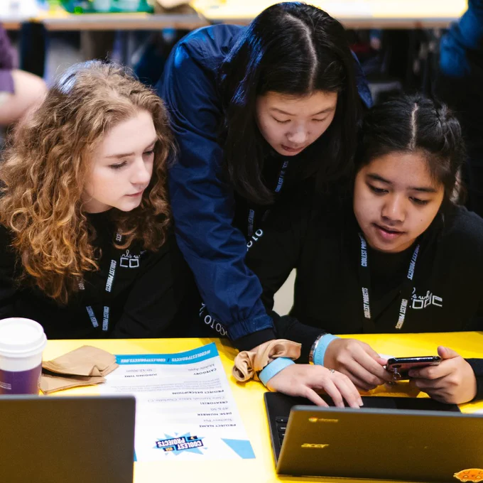 Photo of a group of three young people working together on a laptop.