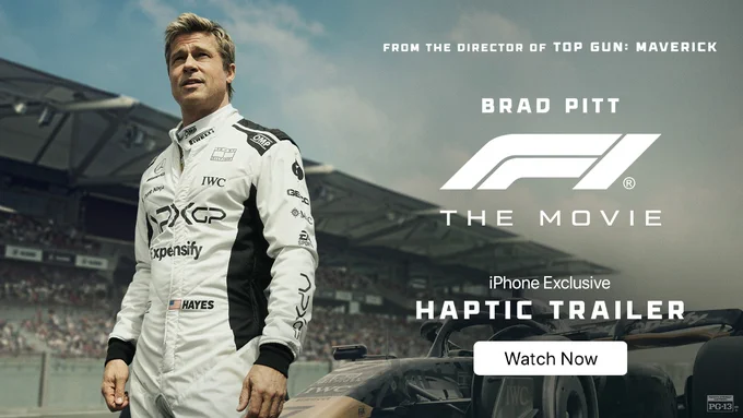Brad Pitt as Sonny Hayes in F1 The Movie wears a white and black racing suit while looking at the crowd at a Formula 1 race. To the right of him text reads, “From the director of Top Gun: Maverick" "Brad Pitt” "F1 The Movie” "iPhone Exclusive Haptic Trailer” and "Watch Now.”