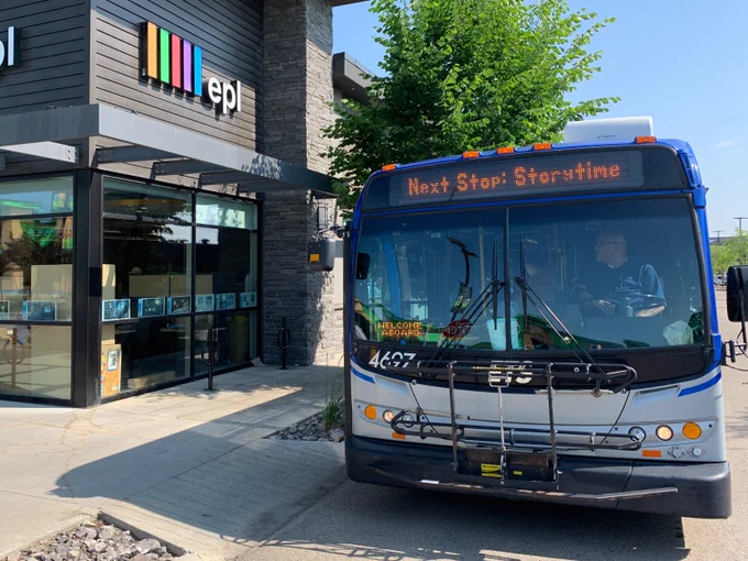 Photo of a bus parking in front of a library with the display “Next Stop: Storytime”