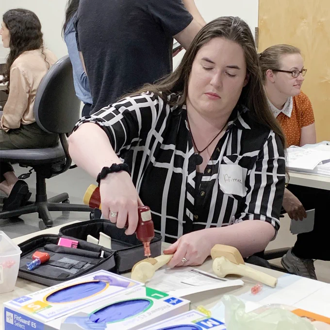 An intern practices drilling into a simulated bone.