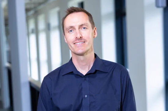 man smiling in blue shirt