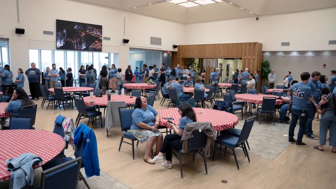 [ID: Pictured is a photo of UTA Libraries staff members waiting in line for food at the staff family picnic.]