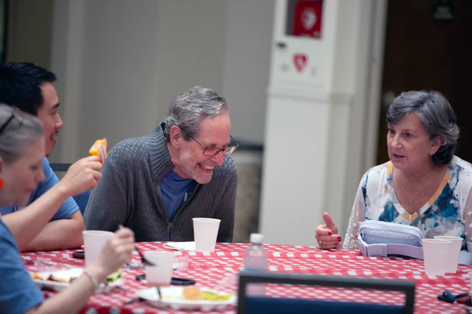 [ID: Pictured is a photo of UTA Libraries staff member Andrew Leverenz laughing at a funny story at the staff picnic on June 11.]