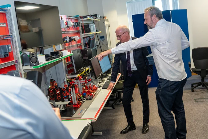 Image shows Queen's staff showing the Minister some of the facilities.