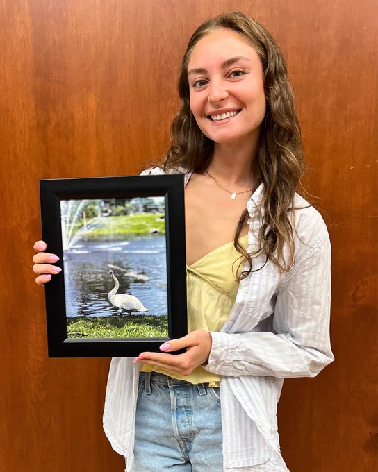 Camryn Trizzino poses proudly with her framed photo.