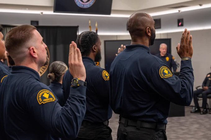 Officers raising their right hands as they take their oath during a swearing-in ceremony.