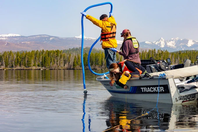 USGS hydrologic technicians collect water samples and use a secchi disk to measure water transparency on Shadow Mountain Lake near Grand Lake, Colorado.