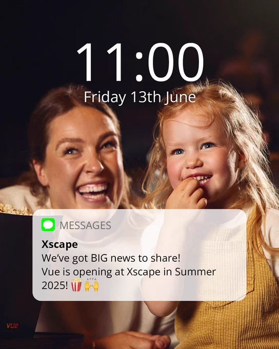 Two people laughing together while watching a screen showing a Vue announcement about opening at Xscape in Summer 2025, displayed on a device indicating the time as 11:00 on June 13th.