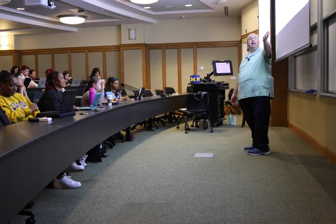 Professor pointing to board as he instructs the class.