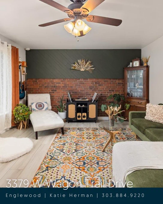 Modern living room featuring a brick accent wall, warm-toned furniture, colorful rug, and ceiling fan. The room is decorated with plants and has a fan light fixture. Contact information for Katie Herman and a property location in Englewood are displayed.