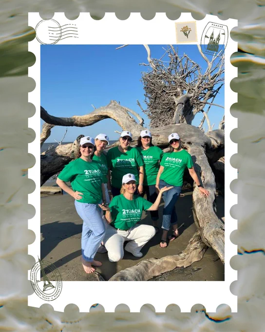 A group of six women pose together on a beach in front of large driftwood and a bright blue sky. They are all wearing matching green “2Teach Global” T-shirts and white baseball caps. Dr. Murawski is kneeling in front while the others stand close behind her, smiling and striking fun poses. The photo is framed with a decorative stamp-like border featuring travel-themed icons such as passport stamps and postmarks.