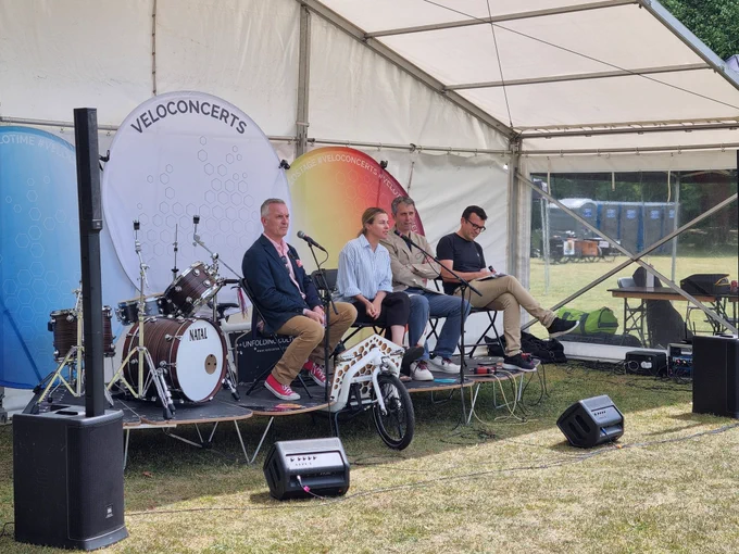A panel discussion on a stage folding out from a Cargo Bike with Cllrs Gareth Roberts and Alexander Ehmann alongside Will Normal amd Nicola Pastore