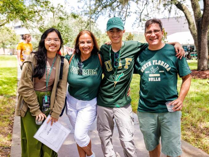 A family posing in front of the USF Judy Genshaft Honors College