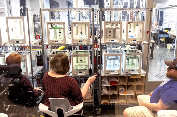 Three UNC makers wait for their 3D prints to finish in Carolina's makerspace
