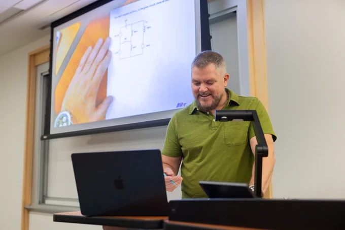 Virginia Tech ECE collegiate assistant professor Arthur Ball writes through an example problem for his circuits and devices class.