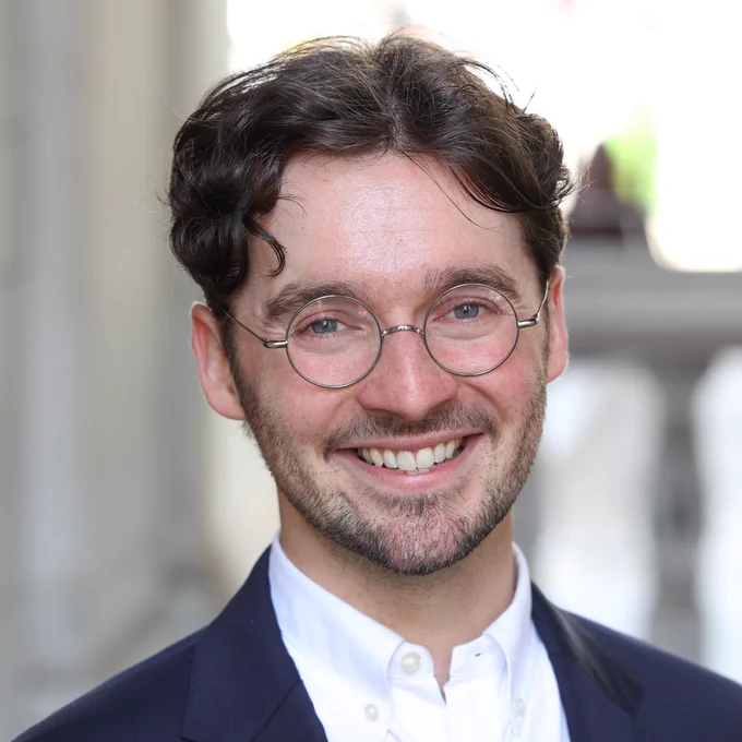 Colour head and shoulders photo of Dr Nathanael Vette smiling at the camera
