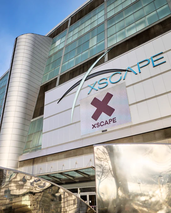 Exterior view of the Xscape entertainment complex in Milton Keynes under a clear blue sky,