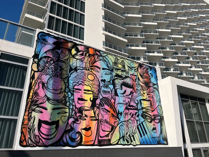 A vibrant and colourful mural depicting a collage of various stylised faces on the side of the Eden Roc Miami Resort hotel building.
