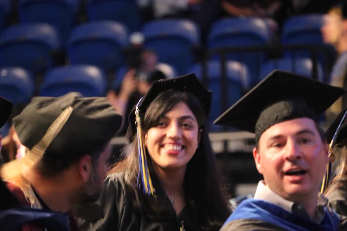 A smiling graduate waiting for the ceremony to begin