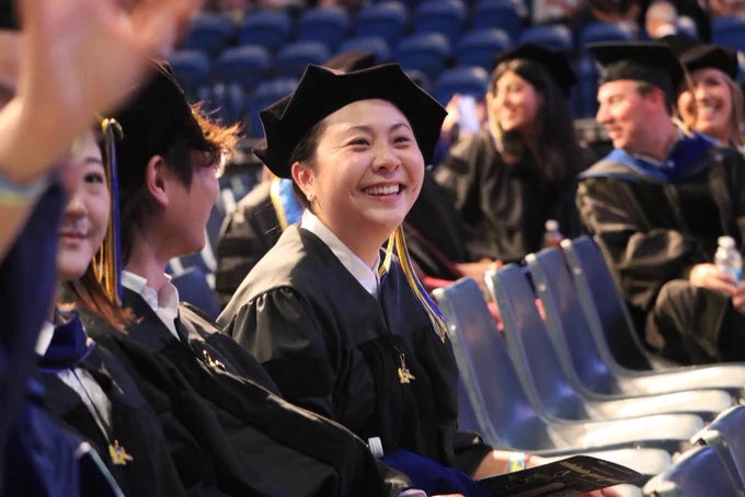 A smiling graduate waiting for the ceremony to begin