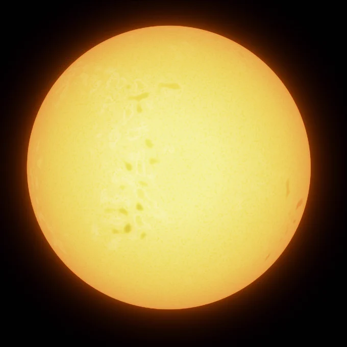 Illustration of a G-type star radiating a bright yellow glow against the dark backdrop of space. Its surface is speckled with faint dark spots, hinting at sunspots caused by magnetic activity.