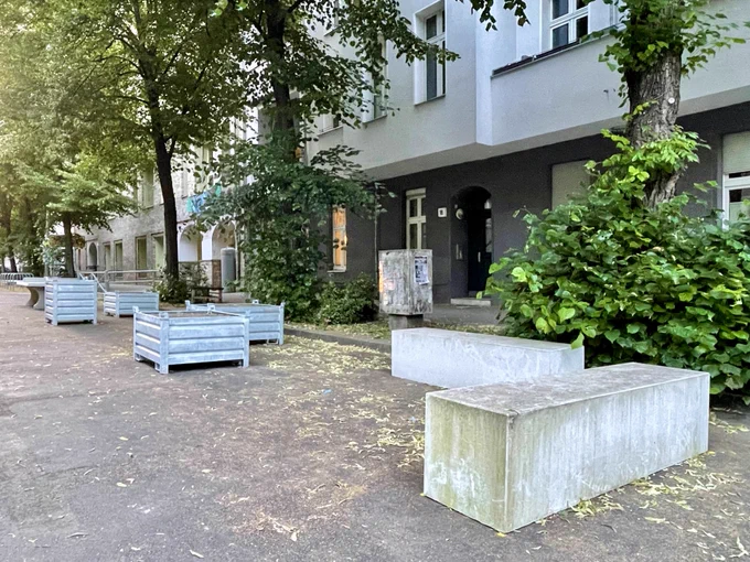 Das Foto zeigt Betonmöbel und Pflanzkästen aus Stahlblech in der autofreien Schulzone vor der Jane-Goodall-Grundschule in der Scharnweberstrasse in Berlin-Friedrichshain.