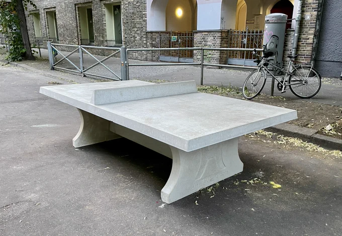Das Foto zeigt  eine neue Tischtennisplatte aus Beton in der autofreien Schulzone vor der Jane-Goodall-Grundschule in der Scharnweberstrasse in Berlin-Friedrichshain.