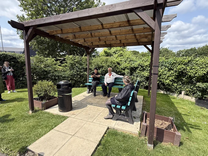Two walk attendees and The Mayor of Barnet sat underneath a pergola. 
