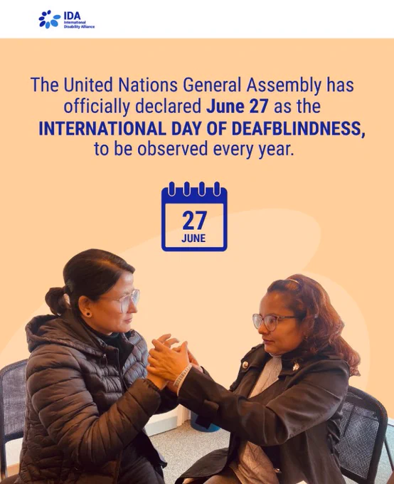 poster from the International Disability Alliance announces that the United Nations General Assembly has officially declared June 27 as the International Day of Deafblindness, to be observed annually. Below the announcement, two women wearing glasses are seated and communicating through tactile sign language, holding each other's hands. A calendar icon displaying "27 JUNE" is centered between the text and the photo.