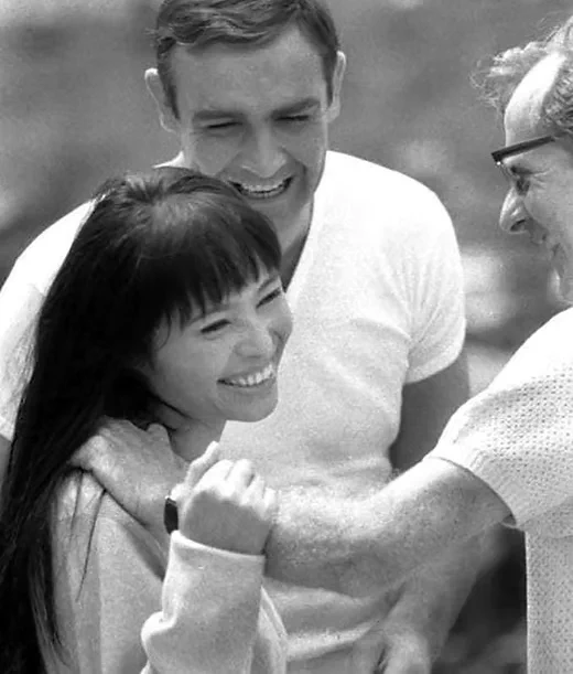 Sean Connery laughs with Akiko Wakabayashi and director Lewis Gilbert during a rehearsal at Kobe Docks for You Only Live Twice (1967). Though Connery faced challenges on location, moments like this reflect the camaraderie he sometimes found on set.
