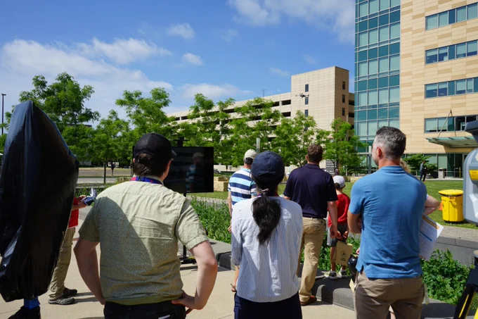 A group of attendees at the Safety Open House event outside Hill Farms State Office building looking at a police drone demonstration. 