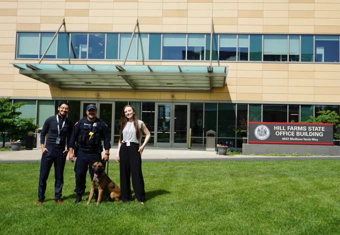 Two DOA LTE Communications Specialists alongside Wisconsin State Patrol Officer and K-9 at the Safety Open House event at Hill Farms State Office building.