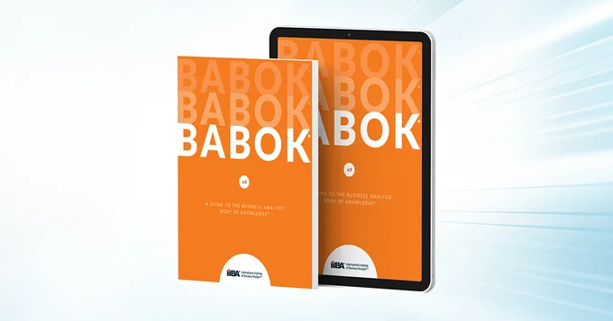 Two covers of the BABOK Guide: one the paperback version, the other on a tablet
