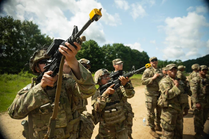Multiple soldiers aim guns into the sky