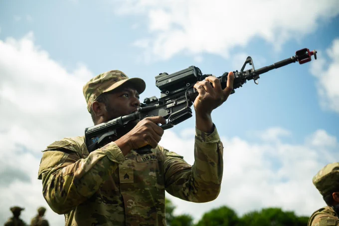 A soldier points a gun at the sky