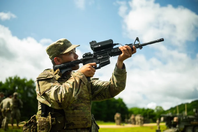 A soldier points a gun at the sky