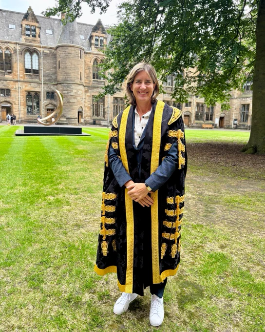 Dame Katherine Grainger, University of Glasgow Chancellor standing in the quad smiling at the camera. Wearing special graduation robes at Commemoration Day. 