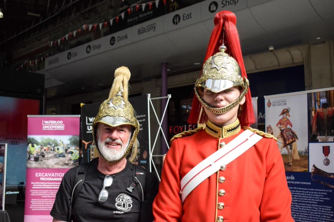 Image shows Life Guard Tpr Davis with SWR customer wearing helmet at London Waterloo.