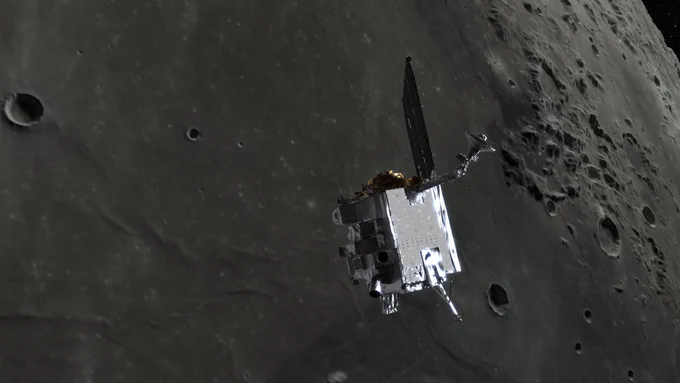 A boxy spacecraft shines in reflected sunlight above the grey cratered surface of the Moon.