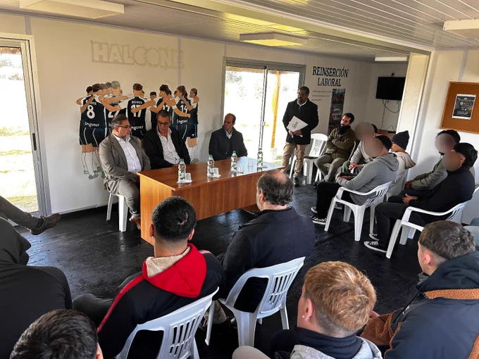 grupo de adolescentes y adultos sentados en el acto de firma de comodato. Espacio Halcones realizado con contenedores . 