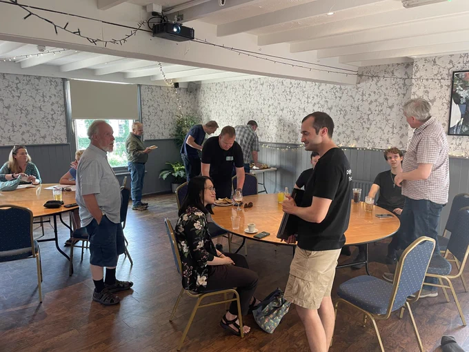 Early arrivals for the WordPress meetup in Cheltenham, people networking,  chatting and digging into sandwiches
