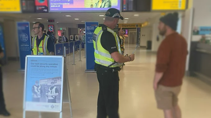 A police officer at Aberdeen speaks with a passenger