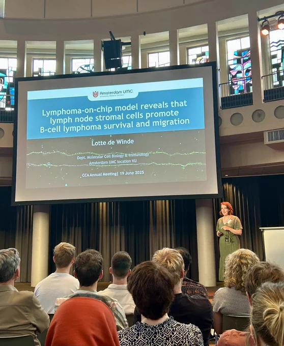Lotte de Winde standing in front of her title slide « Lymphoma on a chip model reveals that lymph node stromal cells promote B cell lymphoma survival and migration »