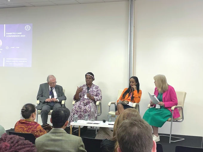 Four panelists are seated in a discussion at the Diabetes Care Conference 2025, attended by an engaged audience.