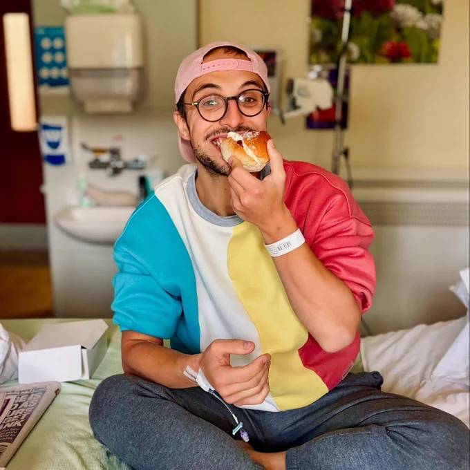 Man sits in hospital bed enjoying a cake