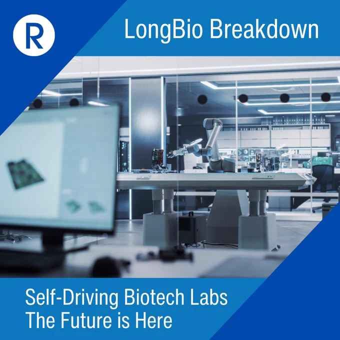 A sleek, modern biotech laboratory featuring a robotic arm conducting experiments on a central lab bench. A computer monitor with scientific schematics is visible in the foreground. The image is overlaid with branding elements including the Revigorator “R” logo and the title “LongBio Breakdown” at the top, with the caption “Self-Driving Biotech Labs – The Future is Here” at the bottom.