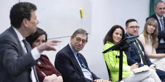 Fordham Law Professor Bruce Green listens intently while seated among a group of attentive professionals during a discussion.